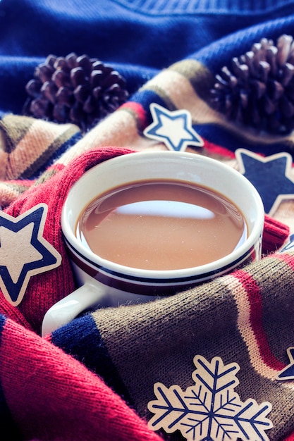 Foto inverno. xícara de café com suéter vermelho. sobre a luz