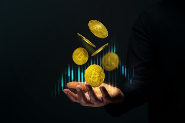 Inversión de dinero en concepto de moneda Crypto. Bitcoin dorado flotando sobre una mano de comerciante. Gráfico del mercado de valores.