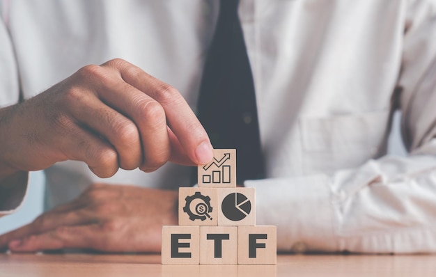 Foto investidor segura o cubo de madeira com ícone bitcoin em pé com texto etf entrando no fundo de dinheiro digital etf exchange traded fund businessfinance conceptualxa