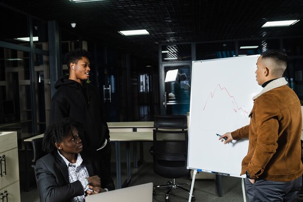 Investidores multiétnicos estão discutindo gráfico de criptomoedas e bitcoin Empresários africanos e asiáticos negros estão discutindo situação financeira econômica juntos