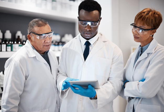 Investigación científica y equipo con tableta en laboratorio para estudio experimental e informe médico Trabajo en equipo de atención médica biotecnología y científicos verifican datos en Internet y resultados para análisis de vacunas