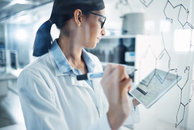 Investigación de tabletas y científica femenina en un laboratorio que planifica una ecuación científica en un tablero Innovación médica tecnológica e investigadora femenina que trabaja en un proyecto farmacéutico con móvil digital