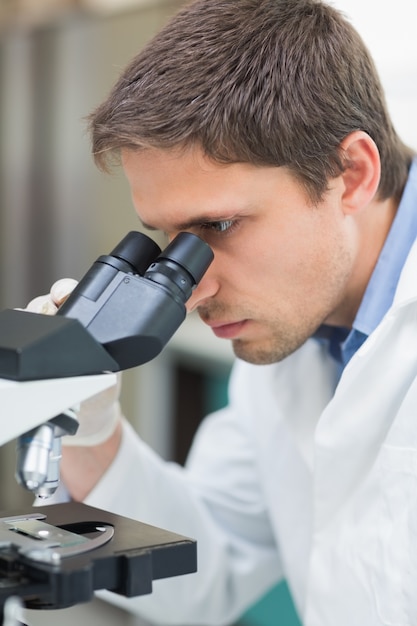 Investigador científico utilizando microscopio en el laboratorio.