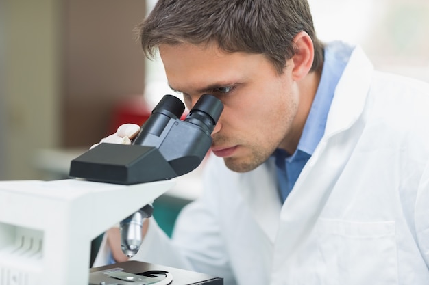 Investigador científico utilizando microscopio en el laboratorio.
