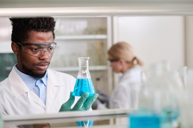 Investigador de laboratorio médico masculino con un frasco