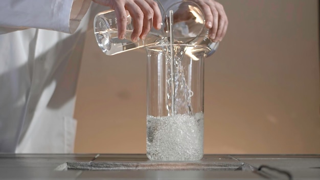 Investigador masculino que lleva a cabo investigaciones científicas en un laboratorio botellas con líquidos en un líquido de laboratorio en el