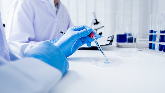 Foto investigador médico o científico o médico hombre mirando un tubo de ensayo de solución transparente en un laboratorio