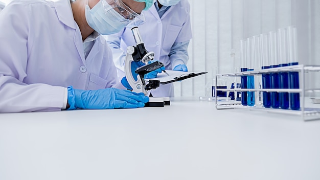Foto investigador médico o científico o médico hombre mirando un tubo de ensayo de solución transparente en un laboratorio
