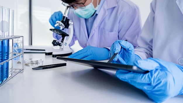 Foto investigador médico o científico o médico hombre mirando un tubo de ensayo de solución transparente en un laboratorio