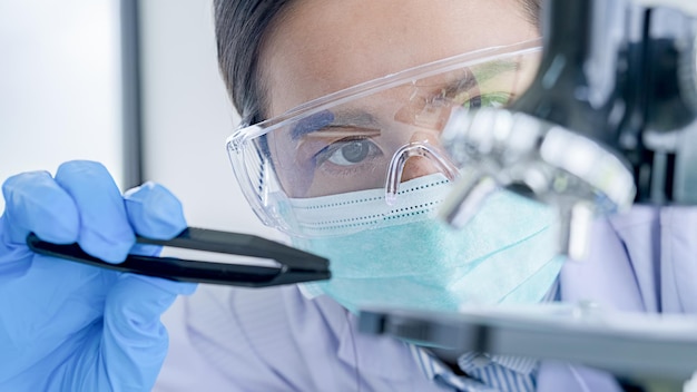 Foto investigador médico o científico o médico hombre mirando un tubo de ensayo de solución transparente en un laboratorio