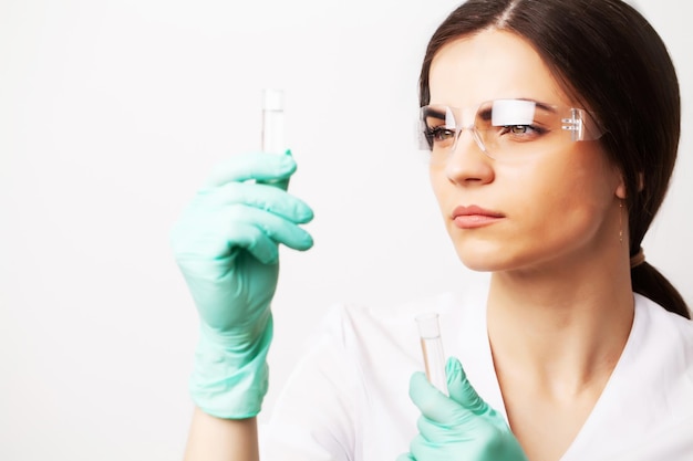 Investigador médico o médico mirando un tubo de ensayo de solución líquida en un laboratorio