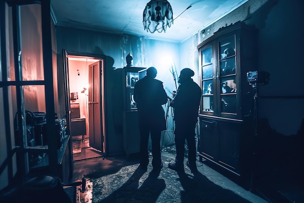 Investigador paranormal examinando locais assombrados Investigadores em salas mal iluminadas com ghosthunti