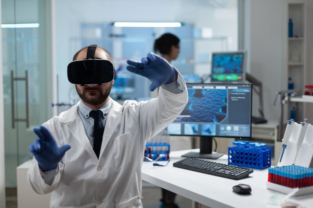 Investigador químico que analiza el desarrollo de la enfermedad mediante casco de realidad virtual