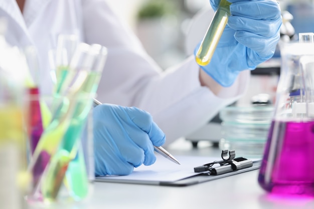 El investigador registra los datos obtenidos de experimentos químicos en tipos de productos químicos de laboratorio