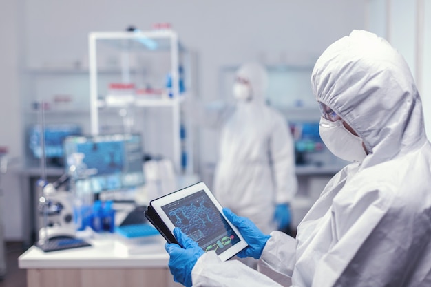 Investigador de la salud analizando virus en tablet pc durante una pandemia global en tablet pc. Equipo de científicos que llevan a cabo el desarrollo de vacunas con tecnología de alta tecnología para investigar el tratamiento contra c