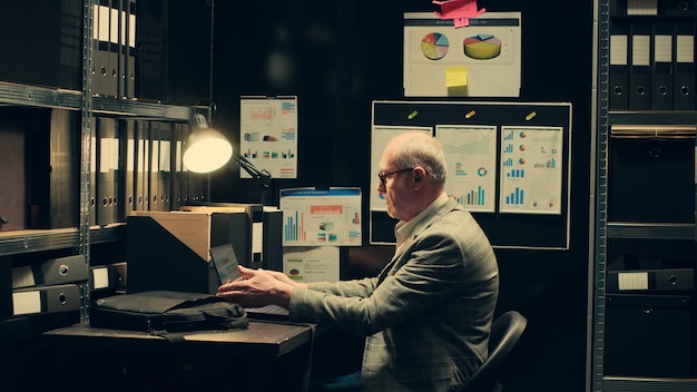 Investigador senior estudiando carpetas de archivo para ver si hay similitudes en los casos.