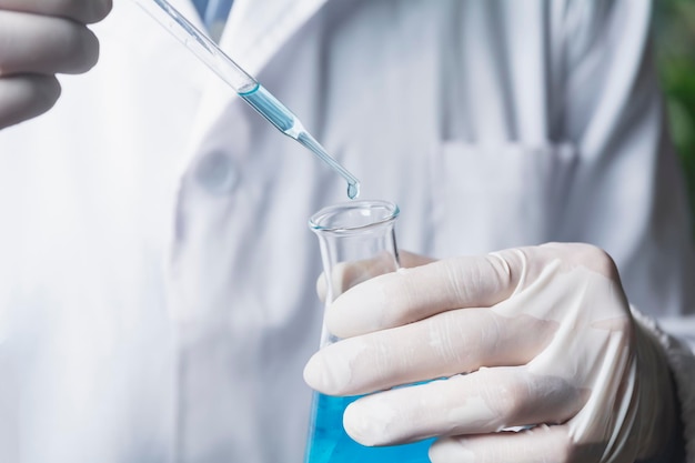 Investigador con tubos de ensayo químico de laboratorio de vidrio con líquido para el concepto de investigación científica y farmacéutica médica analítica
