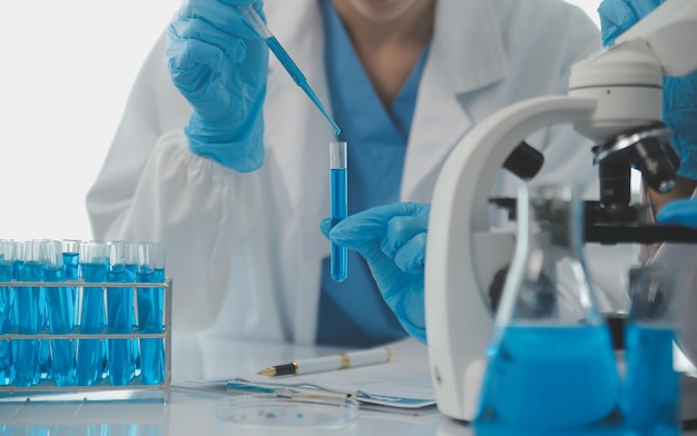 Investigadores de atención de la salud que trabajan en laboratorios de ciencias de la vida Científica investigadora joven y supervisora masculina senior que preparan y analizan portaobjetos de microscopio en el laboratorio de investigación