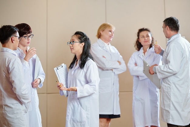 Investigadores hablando en la sala después de asistir a una conferencia médica internacional sobre el desarrollo de la vacuna contra el coronavirus