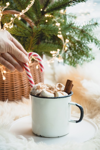 Invierno calentamiento taza de chocolate con malvavisco en el alféizar de la ventana.