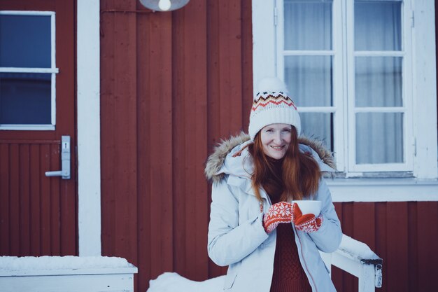 Invierno. chica con una taza en el fondo de rorbu en las islas Lofoten. Noruega