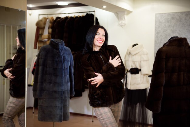 Invierno hermosa mujer en abrigo de piel. Chica modelo de moda de belleza en una tienda de pieles.