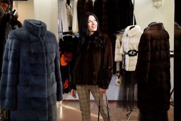 Invierno hermosa mujer en abrigo de pieles. Modelo de moda de belleza Girl In a Fur Store.