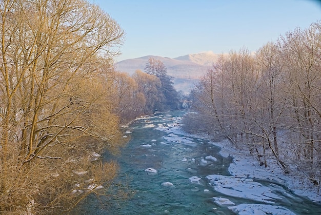 En invierno, el lecho del río descongelado en los bancos cubiertos de nieve fondo de invierno