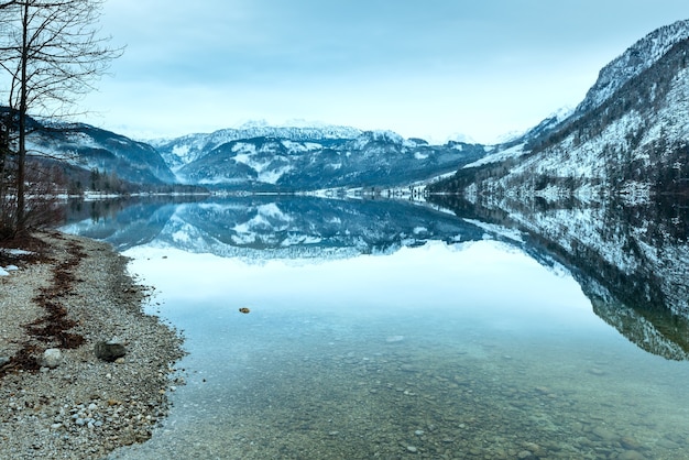 Invierno nublado Vista del lago alpino Grundlsee (Austria) con un patrón fantástico de reflexión sobre la superficie del agua.