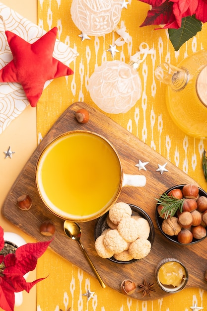 Foto invierno plano con té de jengibre, galletas, nueces y decoración navideña en la mesa