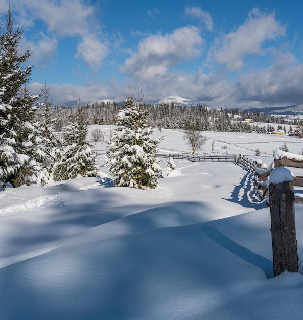 Invierno remoto pueblo de montaña alpino afueras campo colinas arboledas y tierras de cultivo