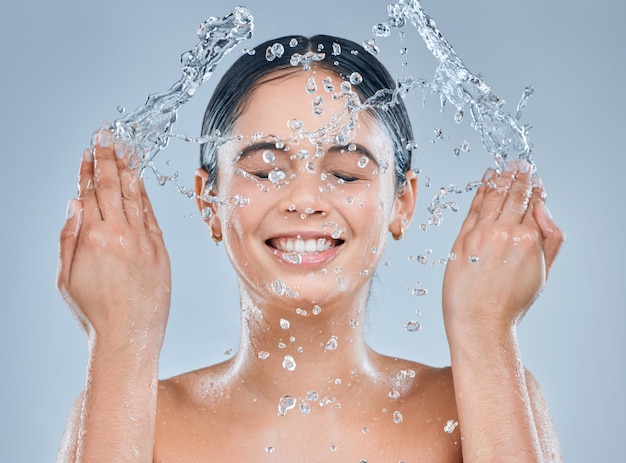Invista em bons cuidados com a pele Foto de uma jovem lavando o rosto no chuveiro contra um fundo cinza