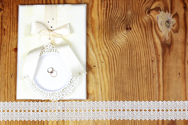 Foto invitación de anillo de bodas sobre fondo de madera