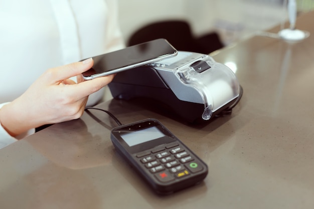 Invitado en la recepción del hotel pagando con cheque durante el check-in