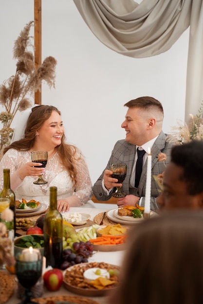 Foto invitados que asisten a la boda y comen en la mesa.