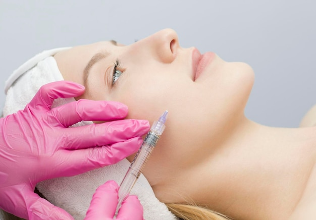 Inyección en la cara en el salón de spa Las manos del médico Biorevitalización Cuidado facial con ácido hialurónico