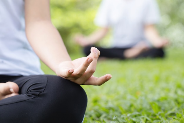 Ioga no parque. Levante as mãos de uma mulher fazendo meditação