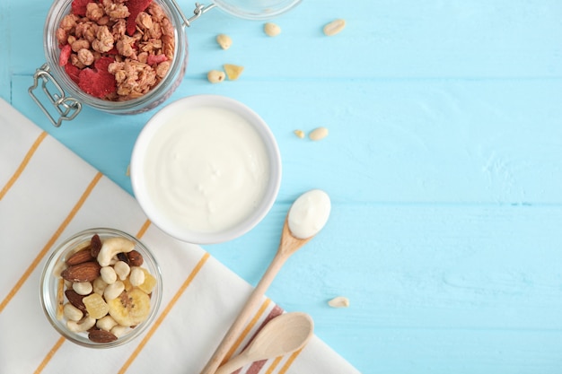 Iogurte com granola de frutas e nozes na vista de cima da mesa