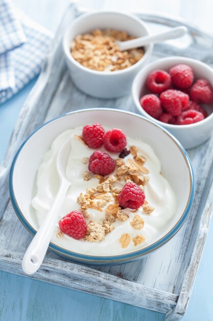 Iogurte com granola e framboesa no café da manhã saudável