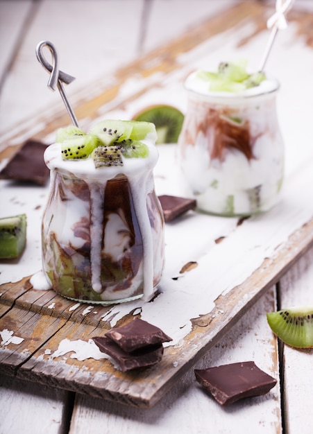 Iogurte com kiwi e chocolate, cozido em potes de vidro.