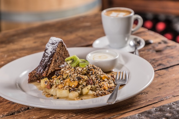 Foto iogurte de mistura de cereais e frutas perto de café