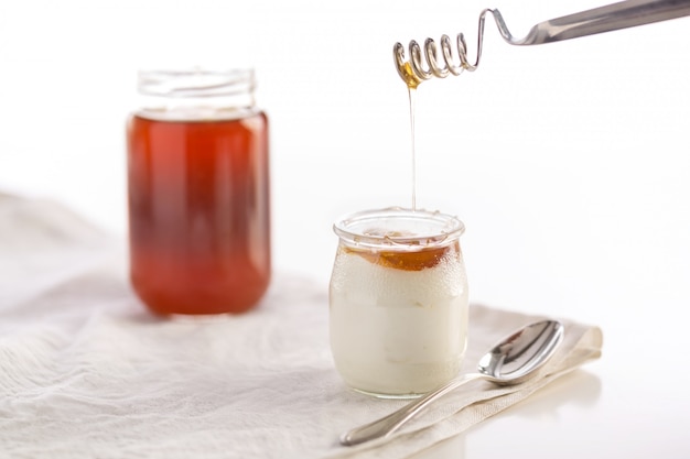 Iogurte em frasco de vidro com colher e mel