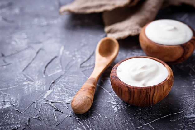 Iogurte grego branco em tigela de madeira