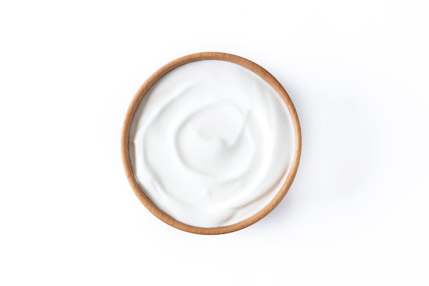 Iogurte grego em uma tigela de madeira isolada no fundo branco