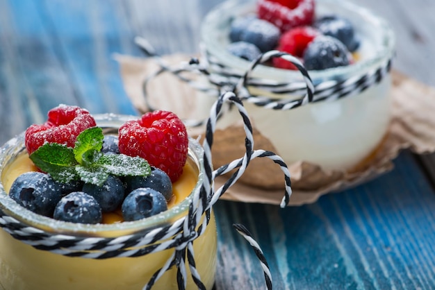 Iogurte natural fresco e saudável com frutas na mesa de madeira