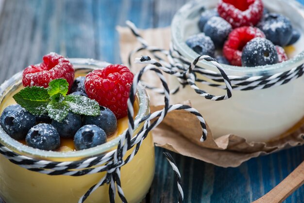 Iogurte natural fresco e saudável com frutas na mesa de madeira