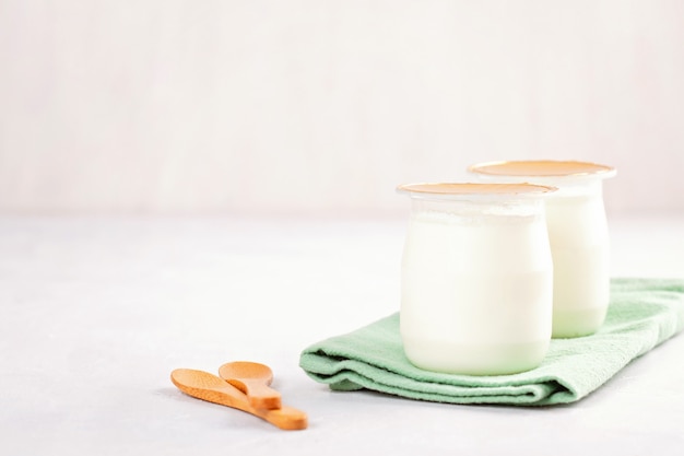 Iogurte natural industrial em latas de plástico. conceito de pequeno-almoço saudável e rápido