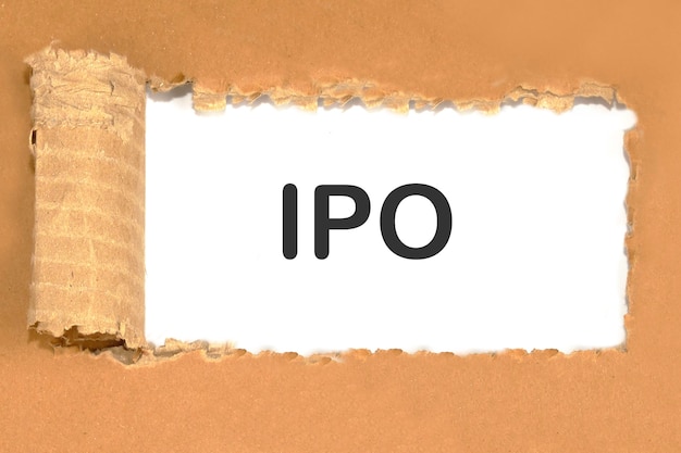 IPA symbolisiert das Konzept eines Börsengangs von Aktien auf Papier unter zerrissener Pappe