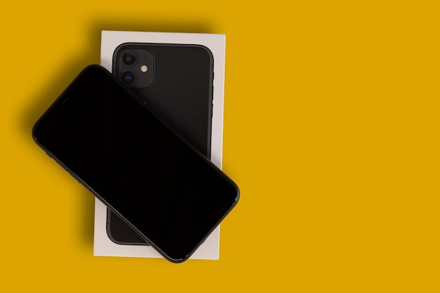 Iphone 11 nuevo en caja sobre fondo amarillo Vista superior