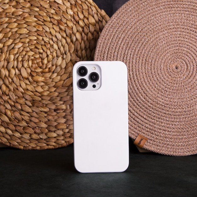 Un iphone blanco con la cámara trasera sobre una mesa